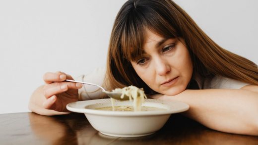 close up of a sad woman eating soup