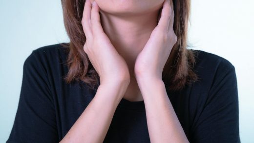 close up of woman touching her tonsils